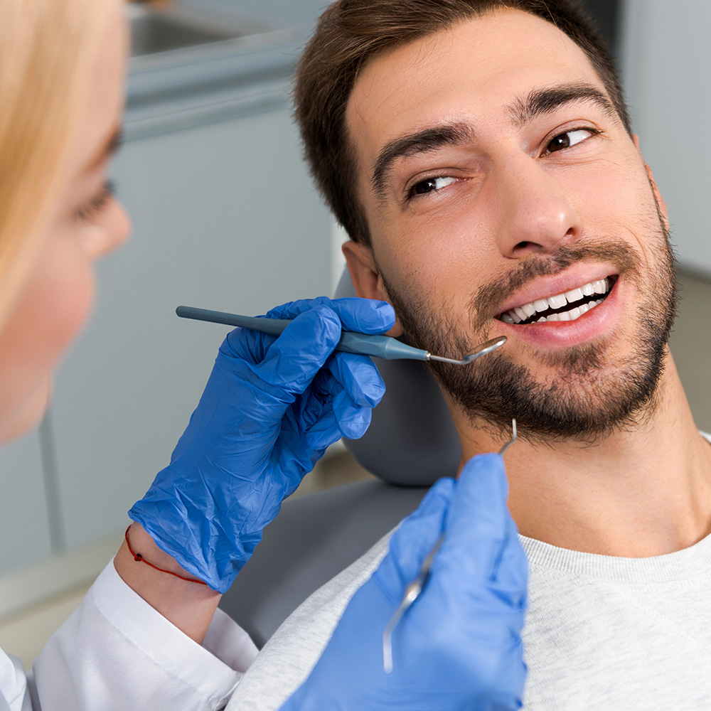 dentista-examina-dientes-paciente